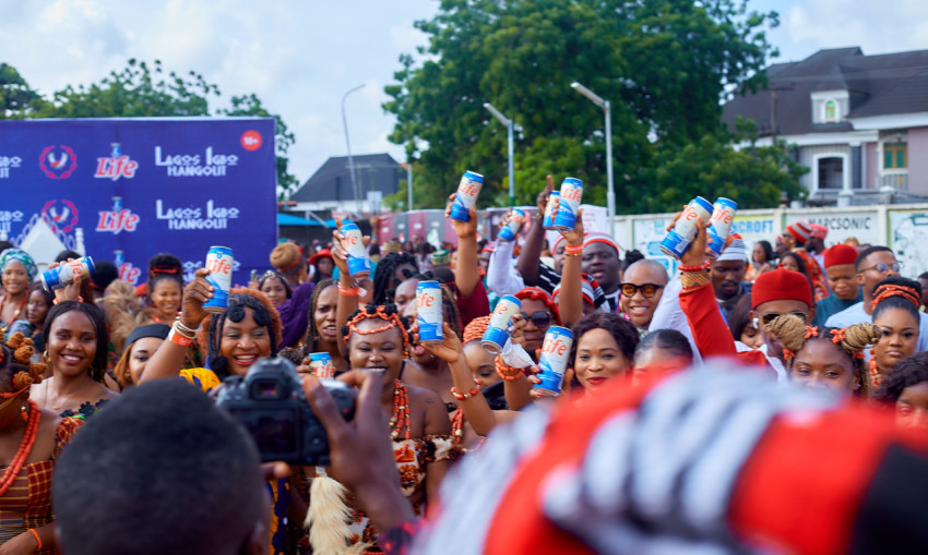 People raising a can drink at an event