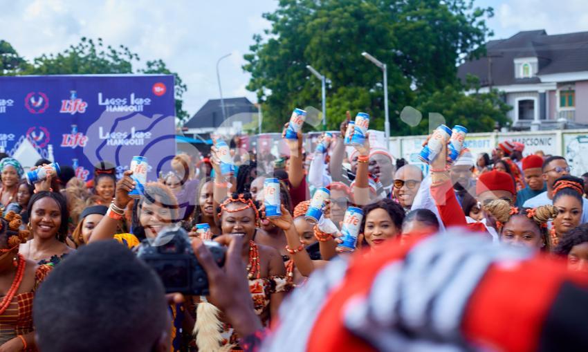 People raising a can drink at an event