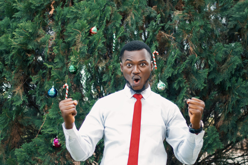 Cheerful man in front of a christmas tree