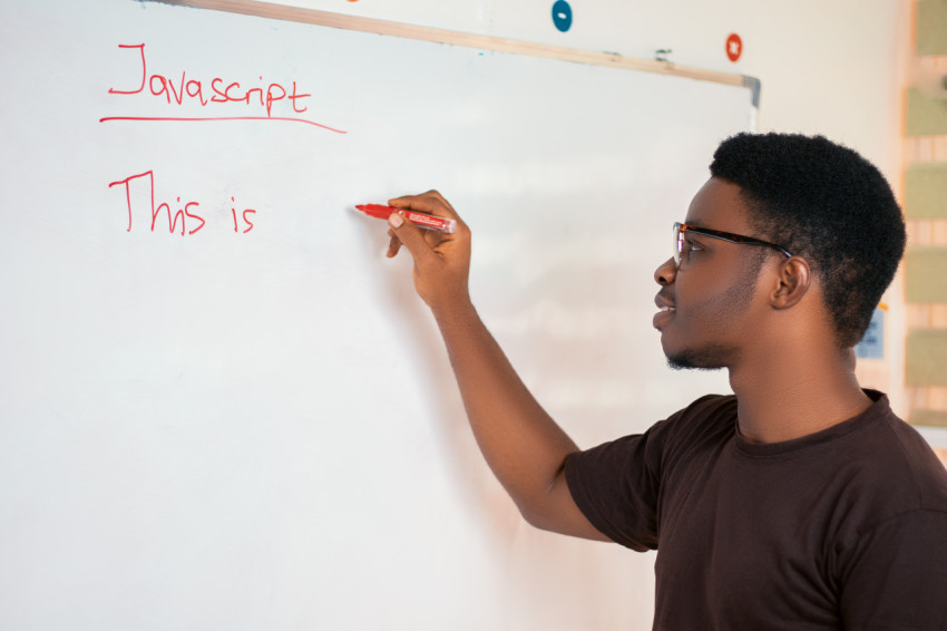 Male teacher writing on a whiteboard 1