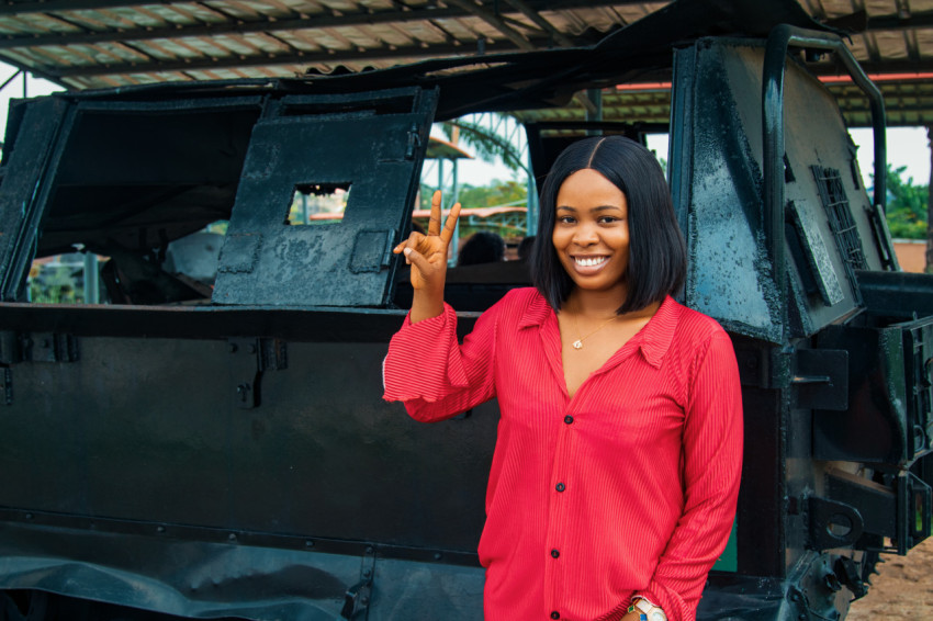 Girl posing in front of an armoured tank