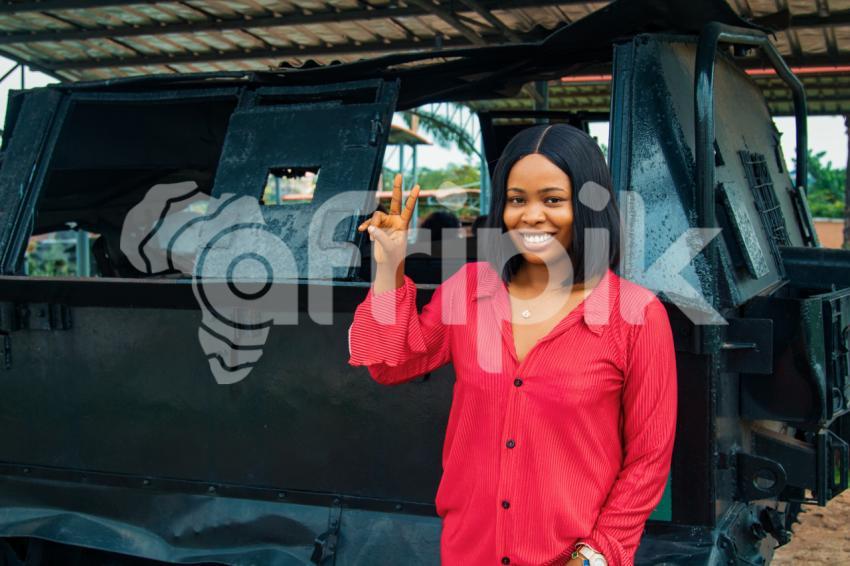 Girl posing in front of an armoured tank