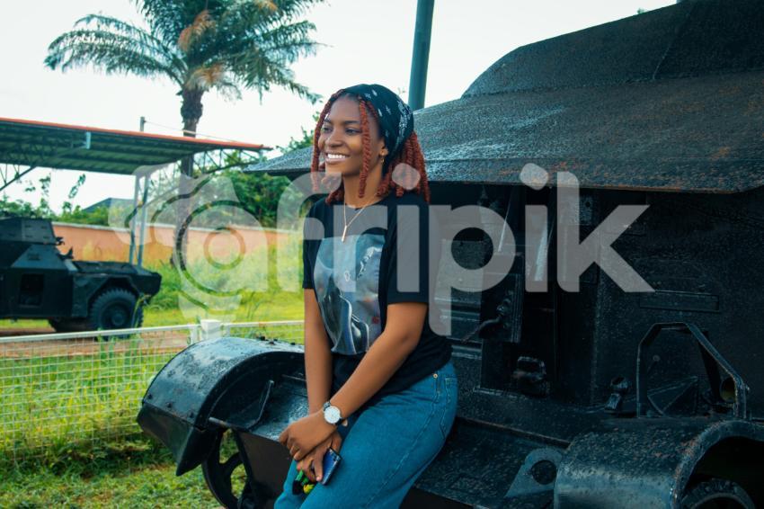 Girl sitting on an armoured tank