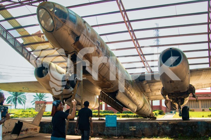 A boy and a girl beneath a war plane