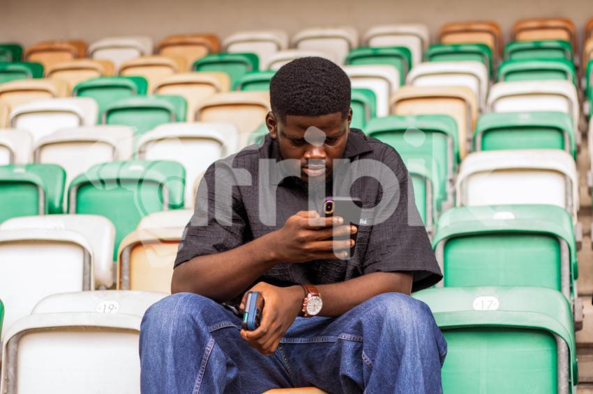 Boy sitting while looking at phone