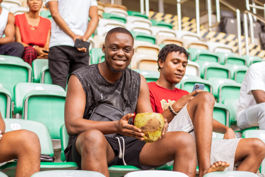 Boy sitting holding coconut drink