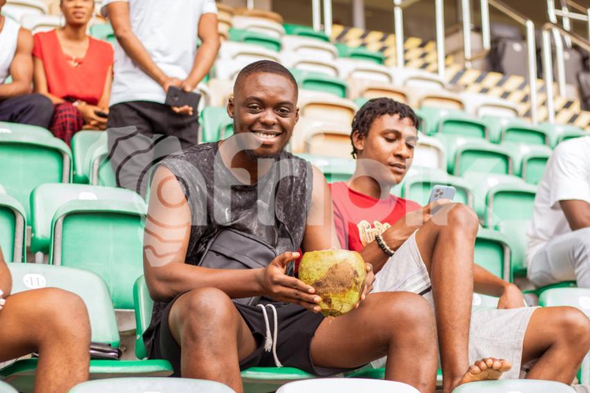 Boy sitting holding coconut drink