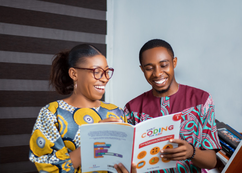 Teachers looking at a coding texbook