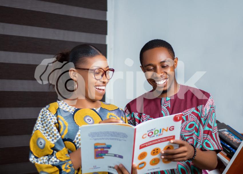 Teachers looking at a coding texbook