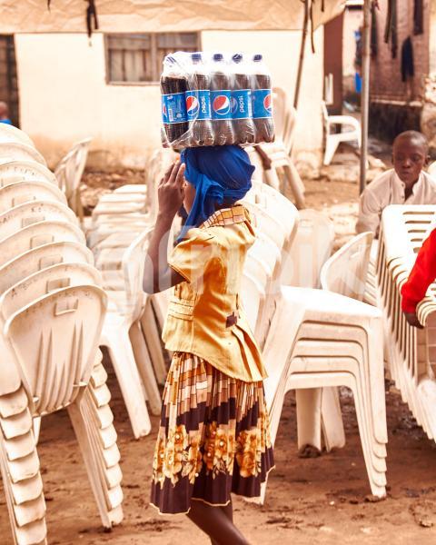 A girl carrying a pack of Pepsi soda