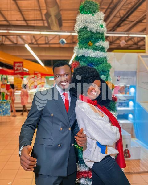 Boy and girl posing in front of a christmas tree