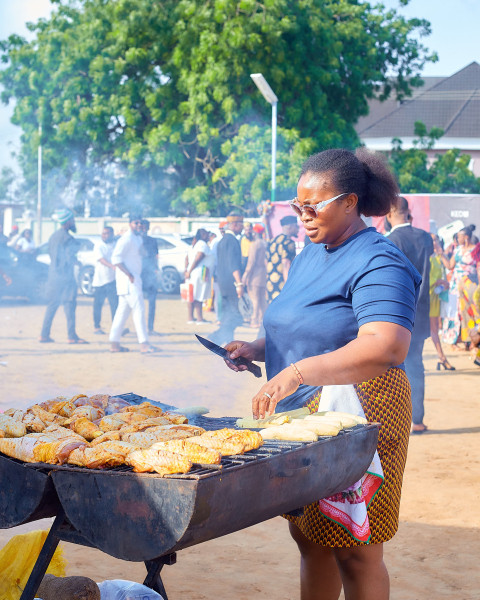 A woman grilling meat using a traditional method