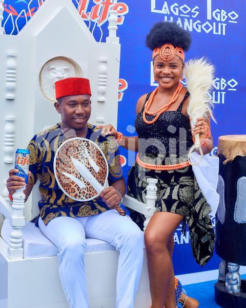 A girl standing beside a boy sitting