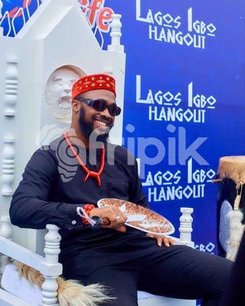 A boy smiling while sitting on a chair