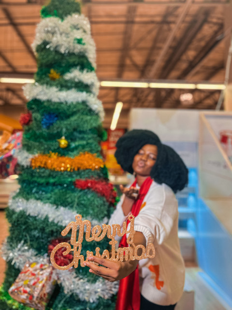 Girl standing beside a christmas tree