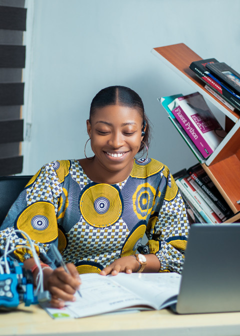 Girl writing in a textbook smiling