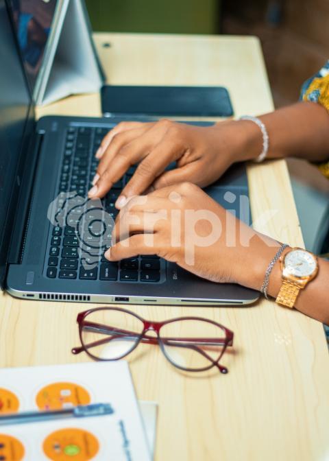 Hands typing on a laptop
