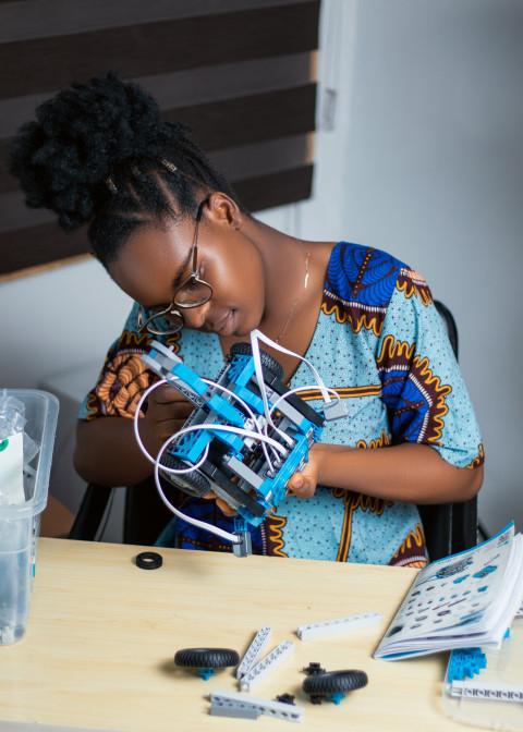 Girl working with her robotics kit 1