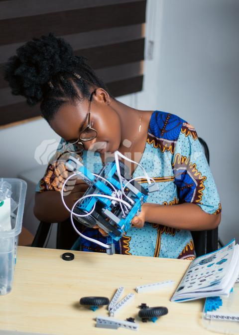 Girl working with her robotics kit 1