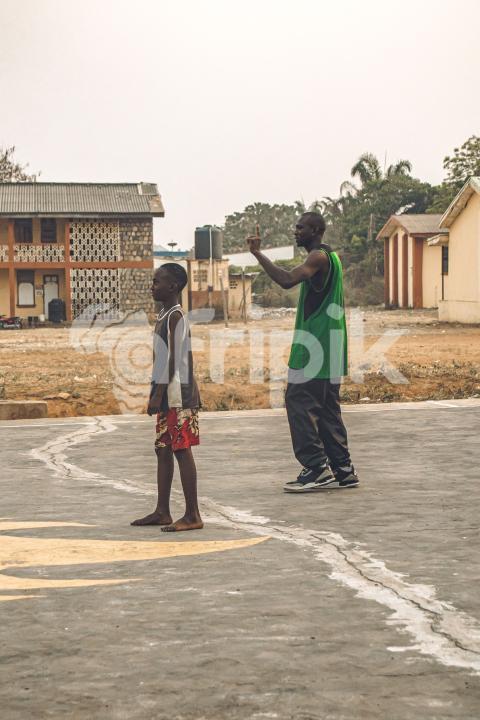 Coach teaching a child how to play basketball