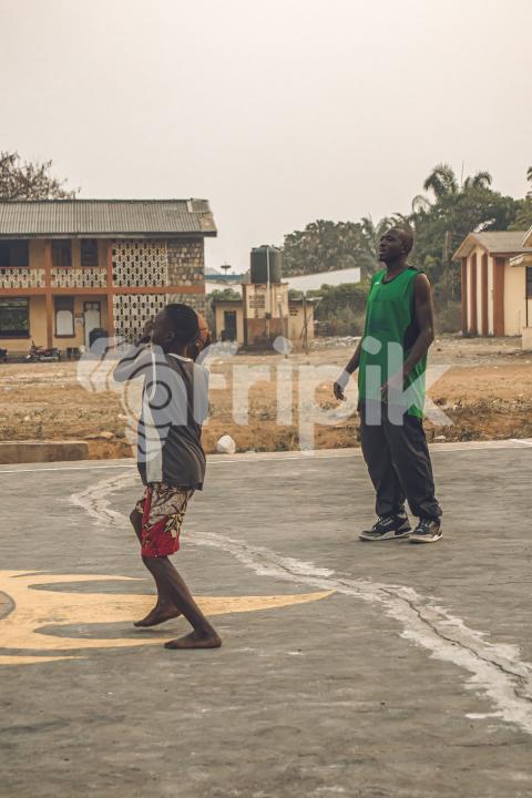 Coach teaching kid how to play basketball