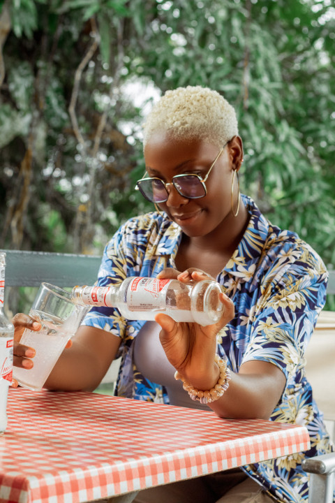 Girl pouring drink into her glass cup