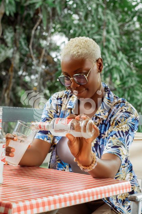 Girl pouring drink into her glass cup
