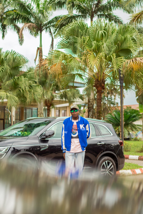 A Boy standing in front of a car