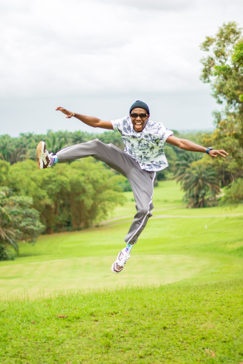 A boy jumping on a beautiful grass lawn