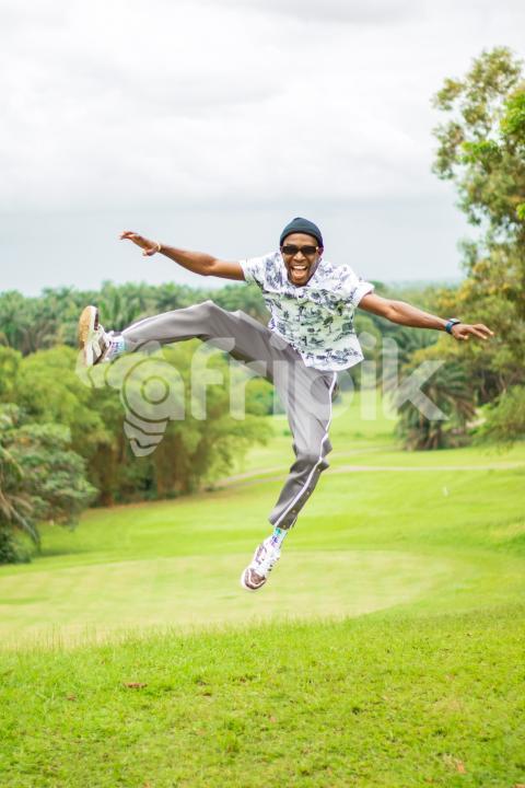 A boy jumping on a beautiful grass lawn